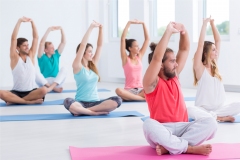 Shot of a group of people sitting with their legs crossed on exercise mats